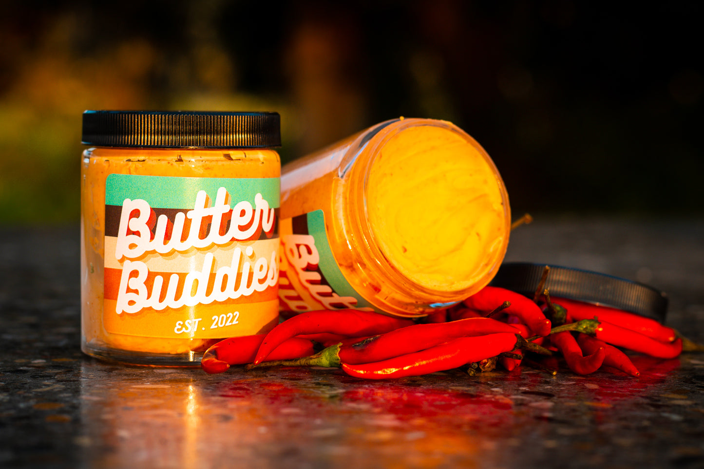Two flavoured honey Chili butters on a bed of hot chili peppers.