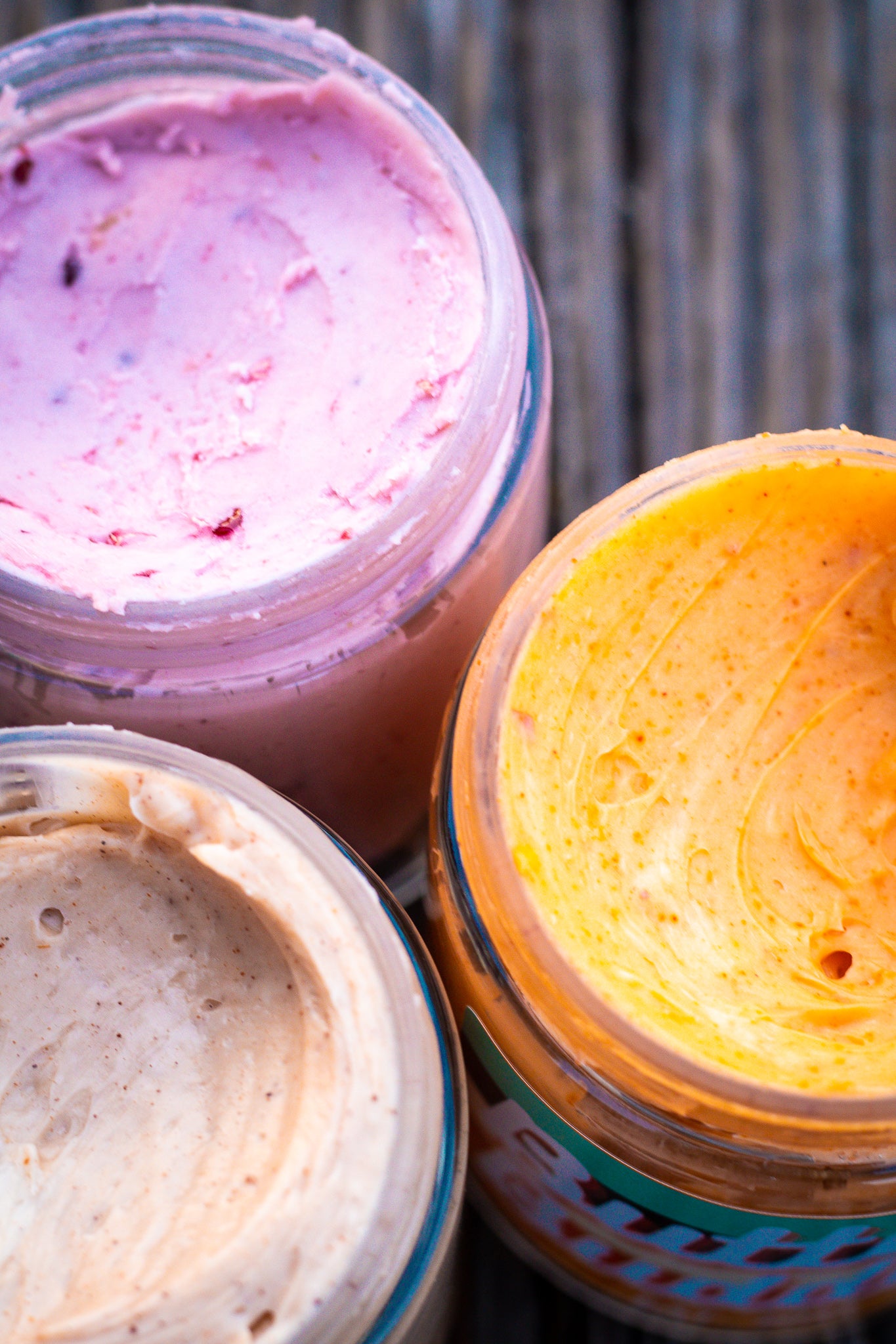 Berry Butter, Honey Chili Butter and Canadian Maple Butter all with lids off, exposing the creamy, fluffy inside.