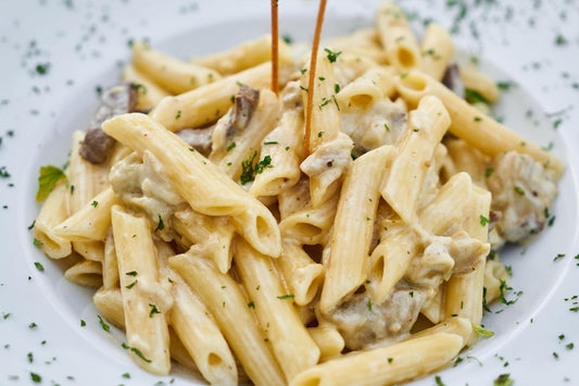 Creamy penne pasta in Alfredo sauce with mushrooms and herbs