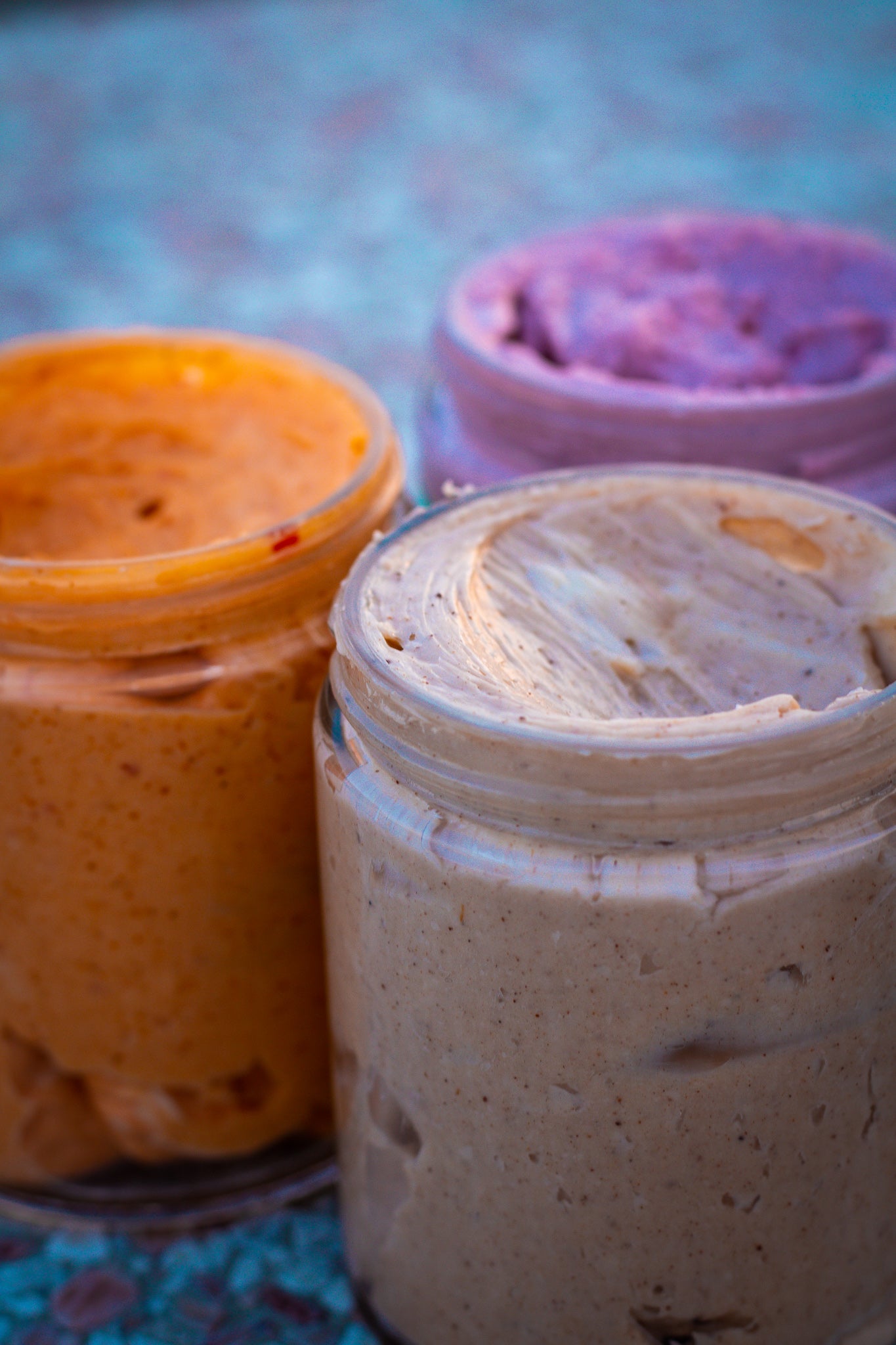 Berry Butter, Honey Chili Butter and Canadian Maple Butter all with lids off, exposing the creamy, fluffy inside. 